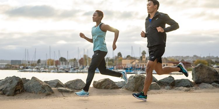Running Shoes for Plyometric Training: A man and a woman running on the shore of a lake